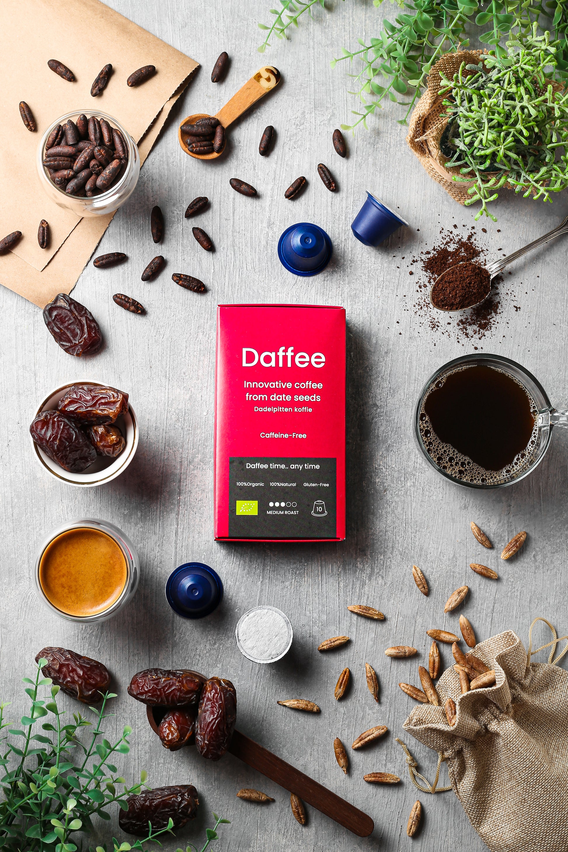 Overzicht van Daffee producten inclusief date seeds, geroosterde bonen, koffiecapsules en vers gezette Daffee, met rode verpakking en plantendecor.