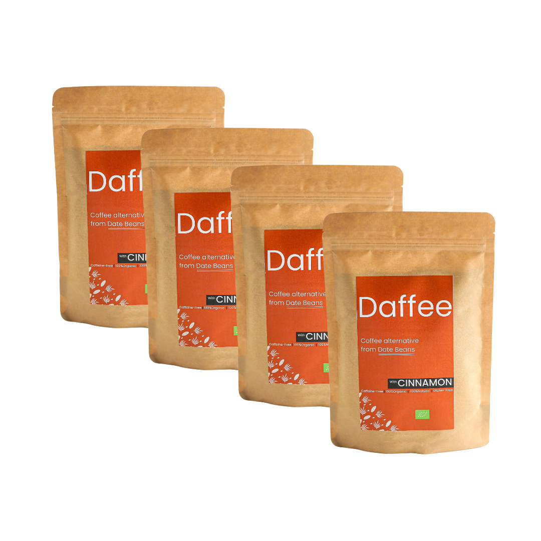 Vier verpakkingen Daffee Kaneel koffiealternatief, gestapeld en uitgelijnd tegen een transparante achtergrond